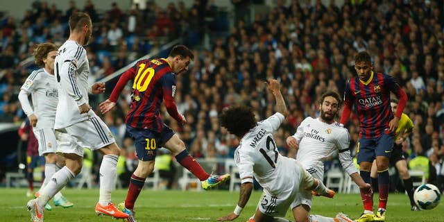 Barcelona's Lionel Messi from Argentina, centre left, scores his goal during a Spanish La Liga soccer match between Real Madrid and FC Barcelona at the Santiago Bernabeu stadium in Madrid, Spain, Sunday, March 23, 2014. (AP Photo/Andres Kudacki)