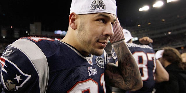 FILE - In this Sunday, Jan. 22, 2012, file photo, New England Patriots tight end Aaron Hernandez puts on a Super Bowl cap following the AFC Championship NFL football game against the Baltimore Ravens in Foxborough, Mass. Hernandez, who was serving a life sentence for a murder conviction and just days ago was acquitted of a double murder, died after hanging himself in his prison cell Wednesday, April 19, 2017, Massachusetts prisons officials said. (AP Photo/Winslow Townson, File)