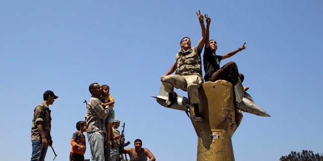 Aug. 24: Rebel fighters celebrate as they stand on top of the monument inside Qaddafi's compound in Bab Al-Aziziya in Tripoli, Libya.