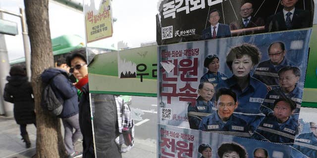 FILE-In this Dec. 19, 2016, file photo, posters showing portraits of impeached South Korea's President Park Geun-hye, center, her aides and business men are displayed at a bus station in Seoul, South Korea. Prosecutors will not be allowed to search South Korea's presidential compound as part of their investigation of the massive corruption scandal that toppled Park from power, the president's office said Thursday, Feb. 2, 2017. The letter read "Arrest." (AP Photo/Ahn Young-joon, File)