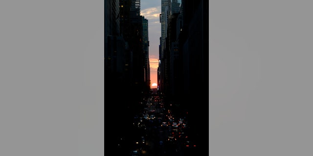 The sun sets through the middle of buildings on 42nd Street in New York's Manhattan borough, during a phenomenon known as Manhattanhenge, Wednesday, July 11, 2012. Manhattanhenge, sometimes referred to as the Manhattan Solstice, happens when the setting sun aligns with the east-to-west streets of the main street grid. The term references Stonehenge, at which the sun aligns with the stones on the solstices in England. (AP Photo/Julio Cortez)