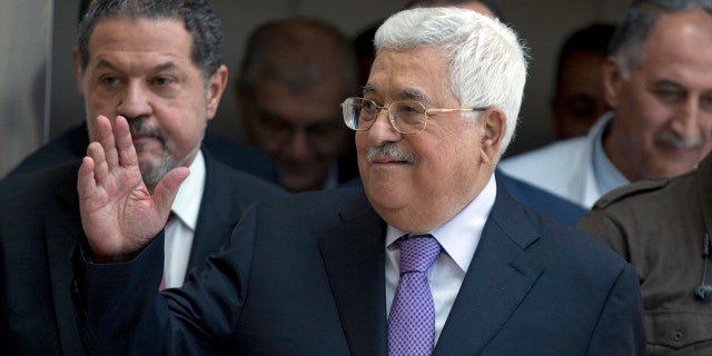 Palestinian President Mahmoud Abbas waves to supporters as he leaves the hospital in the West Bank city of Ramallah, Monday, May 28, 2018.