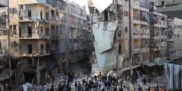 In this Tuesday, Dec. 17, 2013 citizen journalism image provided by Aleppo Media Center, AMC, and released Wednesday, Dec. 18, 2013, which has been authenticated based on its contents and other AP reporting, Syrians inspect the rubble of damaged buildings following a Syrian government airstrike in Aleppo, Syria. Syrian warplanes dumped explosive-laden barrel bombs over opposition-held parts of the northern city of Aleppo on Wednesday, the fourth day of a relentless offensive to drive rebels out of the contested city, activists said. The country's conflict, now in its third year, appears to have escalated in recent weeks as both sides maneuver ahead of next month's planned peace talks and ignore calls for a cease-fire. (AP Photo/Aleppo Media Center, AMC)