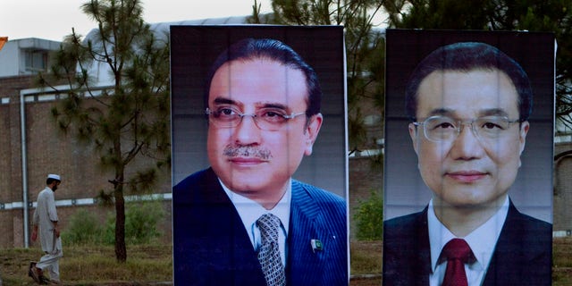 A man walks next to huge portraits of Chinese Premier Li Keqiang, right, and Pakistani President Asif Ali Zardari, left, displayed near the presidency in Islamabad, Pakistan. Keqiang will arrive in Islamabad on May 22 on a two day official visit to hold talks with Pakistani leadership to discuss international, regional issues and enhance co-operation in bilateral ties. (AP Photo/Anjum Naveed)