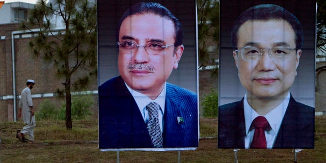 A man walks next to huge portraits of Chinese Premier Li Keqiang, right, and Pakistani President Asif Ali Zardari, left, displayed near the presidency in Islamabad, Pakistan. Keqiang will arrive in Islamabad on May 22 on a two day official visit to hold talks with Pakistani leadership to discuss international, regional issues and enhance co-operation in bilateral ties. (AP Photo/Anjum Naveed)