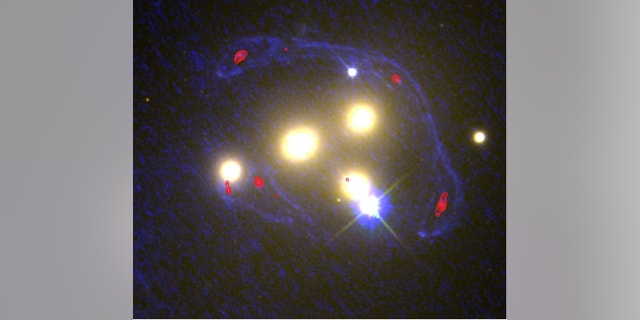 This image shows the four central galaxies in the Abell 3827 cluster with ultraviolet light from the Hubble images (blue) and infrared light from the ALMA observations (red). At these wavelengths, scientists can determine the extent to which a galaxy behind the cluster has been distorted by the gravity of the normal and dark matter.