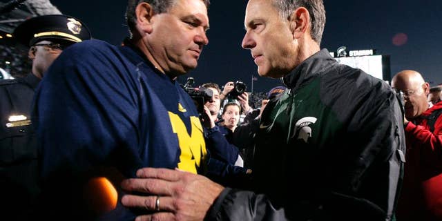 Michigan State coach Mark Dantonio, left, and Michigan coach Brady Hoke talk at midfield before an NCAA college football game, Saturday, Oct. 25, 2014, in East Lansing, Mich. (AP Photo/Al Goldis)