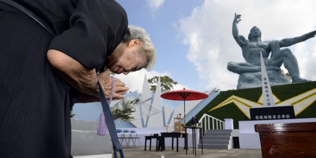 Aug. 9, 2013: A woman offers prayers at Nagasaki Peace Park in Nagasaki, southern Japan to mark the 68th anniversary of the world's second atomic bomb attack over the city.