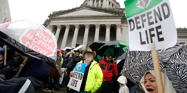 Anti-abortion demonstrators take part in a rally, Tuesday, Jan. 19, 2016, at the Capitol in Olympia, Wash. (AP Photo/Ted S. Warren)