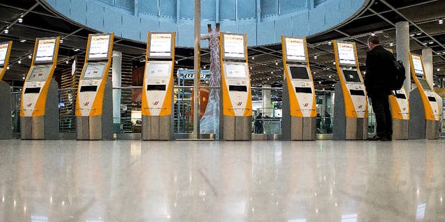 Unused check-in terminals are reflected on the floor in the airport in Duesseldorf, western Germany, Friday morning, March 20, 2015. Lufthansa pilots continue their strike in a dispute centering on the airline's plans to cut transition payments for pilots wanting to retire early, which the union wants to see maintained continues. (AP Photo/dpa, Maja Hitij)