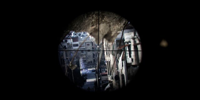 Una calle controlada por fuerzas del gobierno vista a través de la mirilla de un francotirador en el vecindario de Saif al-Dawlah, en Aleppo, Siria, el domingo 13 de enero de 2013. (Foto AP/Andoni Lubaki)