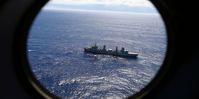 FILE - In this March 31, 2014 file photo, HMAS Success scans the southern Indian Ocean, near the coast of Western Australia, as a Royal New Zealand Air Force P3 Orion flies over, while searching for missing Malaysia Airlines Flight MH370.