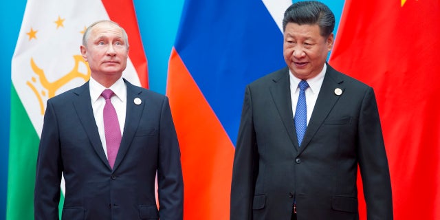 Chinese President Xi Jinping, right, and Russian President Vladimir Putin pose for a photo at the Shanghai Cooperation Organization (SCO) Summit in Qingdao in eastern China's Shandong Province Sunday, June 10, 2018.