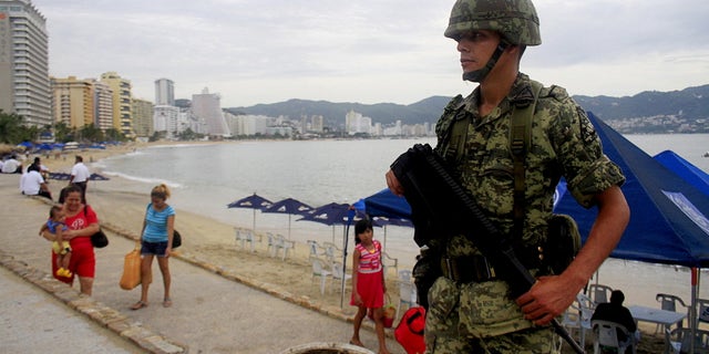 A soldier stands guard along a beach during an operation to help increase security in Acapulco, Mexico.