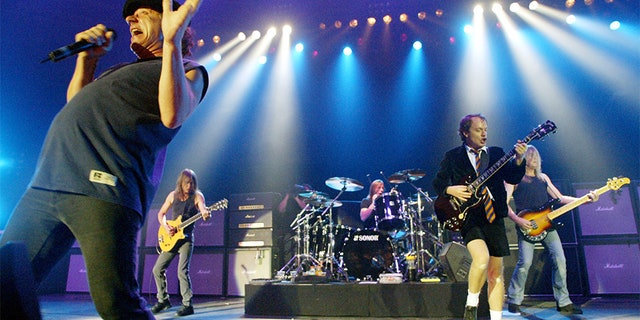 Rock band AC/DC, from left, Brian Johnson, Malcolm Young, Phil Rudd, Angus Young, and Cliff Williams performing on stage during a concert in German in 2003.