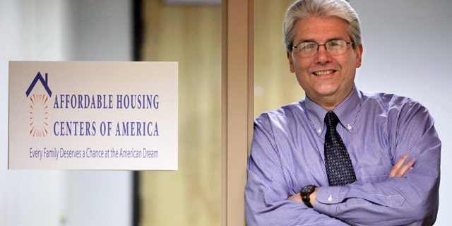 In this photo taken, March 12, 2010, in Chicago, Michael Shea, Executive Director of Affordable Housing Centers of America, formally known as ACORN Housing poses next to the organization's new sign. (AP)