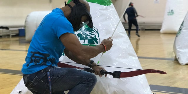 Glenn Davis reloading his bow with a foam tipped arrow, right before shooting a member of the other team. Marietta, GA.