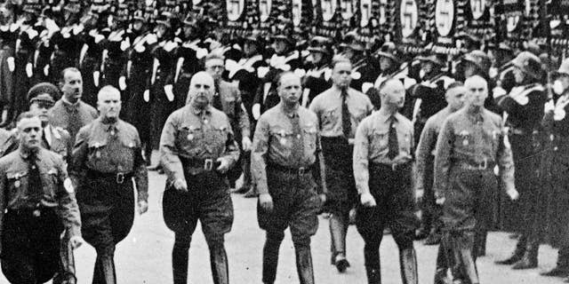 FILE - In this 1938 file photo Heinrich Himmler, second right, chief of secret police and Dr. Wilhelm Frick, right, and other leading members of the Nazi party march along Koenigliche Platz in Munich, southern Germany. A historical commission examining the Nazi links of Germany’s Interior Ministry says more than half of the staffers from 1949 to 1970 had belonged to the Nazi party. In an interim report presented Wednesday, Nov. 4, 2015 the commission said 54 percent of staffers during those years had been former Nazi party members, and many had also been members of the SS or SA. Eight percent had served in the Nazi Interior Ministry, which was run by Wilhelm Frick, who was executed for war crimes, and later SS-chief Heinrich Himmler. (AP Photo/file)