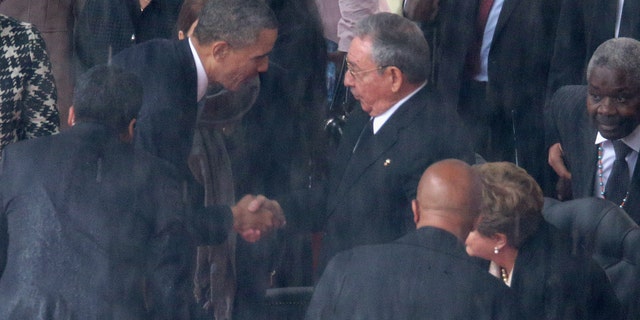 President Obama shakes hands with Cuban President Raul Castro on December 10, 2013 in Johannesburg, South Africa.