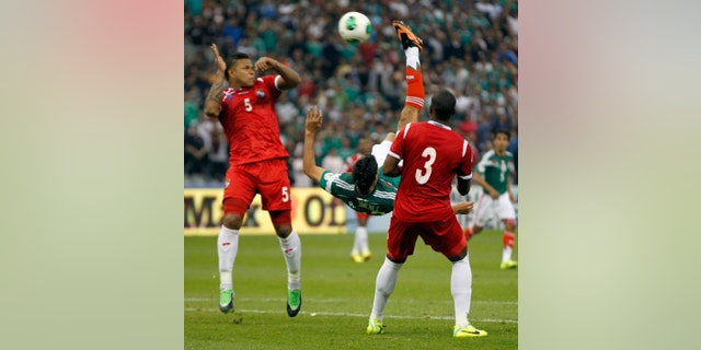 Mexico's Raul Jimenez, center, shoots to score the winning goal against Panama at a 2014 World Cup qualifying match, in Mexico City, Friday, Oct. 11, 2013. Mexico defeated Panama 2-1. (AP Photo/Eduardo Verdugo)