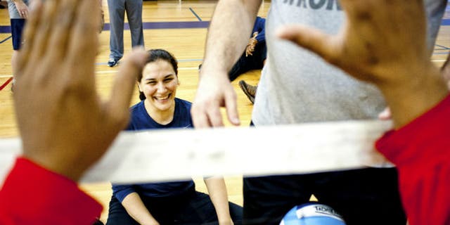 Ensign Laura Root runs through a sitting volleyball drill during an adaptive athletics camp for wounded soldiers at Naval Station Norfolk, Virginia February 8, 2013. REUTERS/Rich-Joseph Facun