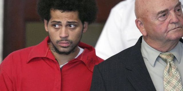 FILE - In this Friday, June 28, 2013 file photo, Carlos Ortiz, an associate of ex-New England Patriot Aaron Hernandez, left, enters the Attleboro District Court with attorney John Connors, right, for his arraignment on weapons charges, in Attleboro, Mass. (AP Photo/The Boston Globe, George Rizer, Pool, File) (The Associated Press)