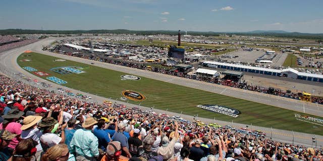Race fans cheer the start of the Talladega 500 NASCAR Sprint Cup Series auto race at Talladega Superspeedway, Sunday, May 3, 2015, in Talladega, Ala. (AP Photo/Butch Dill)