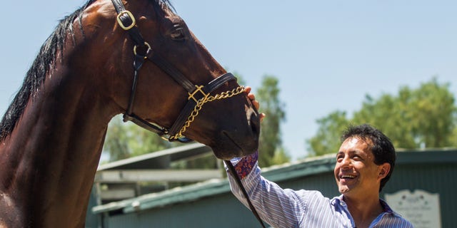 Victor Espinoza greets Triple Crown winner American Pharoah at Santa Anita Park in Arcadia, Calif., Thursday, June 18, 2015.