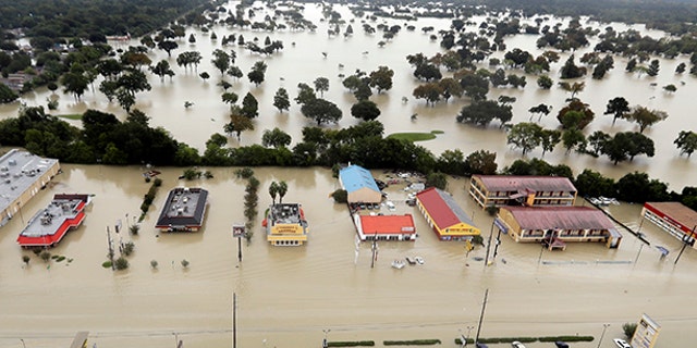 Water from Addicks Reservoir flows into neighborhoods as floodwaters from Tropical Storm Harvey rise Tuesday, Aug. 29, 2017, in Houston.
