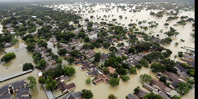 Water from Addicks Reservoir flows into neighborhoods as floodwaters from Tropical Storm Harvey rise Tuesday, Aug. 29, 2017, in Houston.
