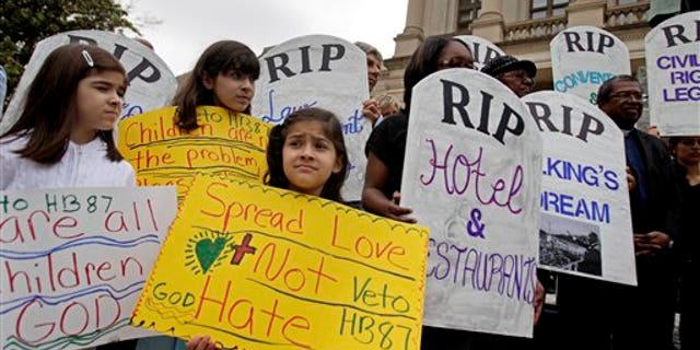 Alexandra Leon, 6, of Atlanta, center, attends a rally against a proposed Arizona-style immigration bill Monday, April 11, 2011 outside the State Capitol in Atlanta. Activist groups delivered a petition Monday Gov. Nathan Deal to urge him to veto the bill that aims to crack down on illegal immigration. (AP Photo/David Goldman)