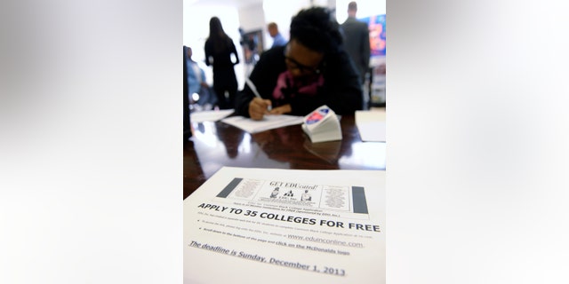 Scheryl Duarte, a senior at Roosevelt High School, fills out a college enrollment application at her school in Washington, Nov. 14, 2013. The schools was hosting a "sit-in" to get high school students who might not otherwise go to college to apply to college. President Barack Obama’s goal is that by 2020, America will again have the highest proportion of college graduates in the world. More low-income and first-generation students must get a degree to reach it. The first hurdle is getting these students to apply. (AP Photo/Susan Walsh)