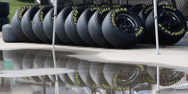 Race tires are stacked next to a rain puddle at Kansas Speedway in Kansas City, Kan., Thursday, May 7, 2015. Wet weather is expected over the weekend. (AP Photo/Orlin Wagner)
