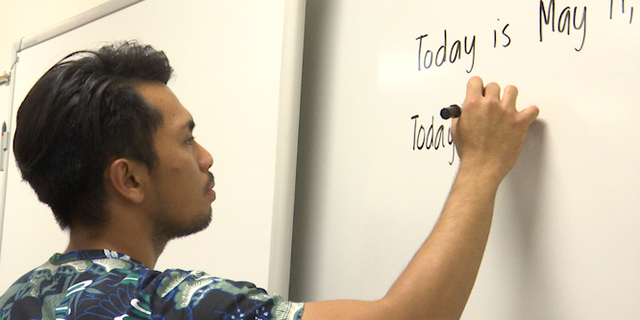 Adrian Calabano, 23, readies his classroom. Filipino and here on a J-1 visa, he teaches sixth grade special education at a junior high school outside Las Vegas.