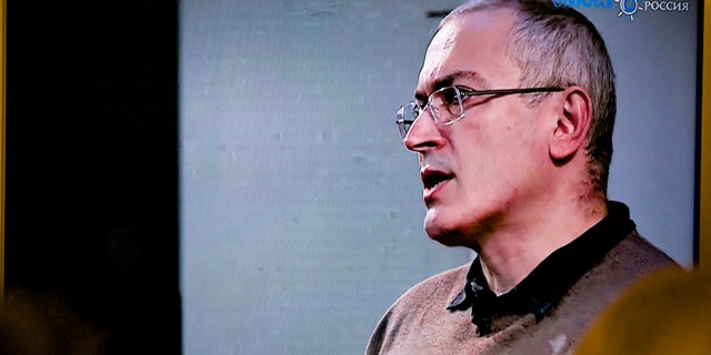 Dec. 9: Mikhail Khodorkovsky, once Russia's richest man, speaks during a webcast conference in London, and is seen on a TV screen in Open Russia movement office in Moscow.