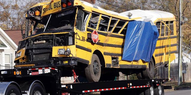 FILE - In a Tuesday, Nov. 22, 2016 file photo, a school bus is carried away, in Chattanooga, Tenn, from the site where it crashed on Monday. Attorney Amanda Dunn says she anticipates bus driver Johnthony Walker will plead not guilty if a grand jury indicts him. He's charged with five counts of vehicular homicide. Police say another count will be added. (AP Photo/Mark Humphrey, File)