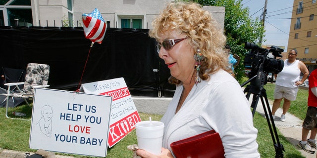July 2- Jackson Women's Health Organization owner Diane Derzis, walks past abortion opponents protesting outside Mississippi's only abortion clinic in Jackson, Miss.