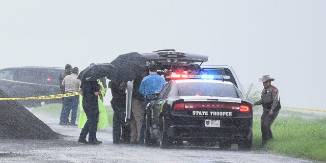 Law enforcement officers gather near the scene where the body of a woman was found near Interstate 35 north of Laredo, Texas on Saturday, Sept. 15, 2018.