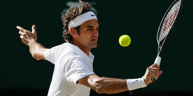 Roger Federer of Switzerland plays a return to Milos Raonic of Canada during their men’s singles semifinal match at the All England Lawn Tennis Championships in Wimbledon, London, Friday, July 4, 2014. (AP Photo/Ben Curtis)