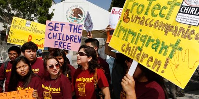 Immigration activists with Coalition for Humane Immigrant Rights of Los Angeles (CHIRLA) demand the Mexican government take more measures to protect and respect the rights of unaccompanied minors and families crossing Mexico's territory, during a protest outside the Mexican consulate in Los Angeles Thursday, July 3, 2014. Activists demand support of migrant children and families Thursday, two days after U.S. Homeland Security buses carrying the migrants were routed away from American flag-waving protesters in Murrieta, Calif., and transported to a facility in San Diego. (AP Photo/Damian Dovarganes)