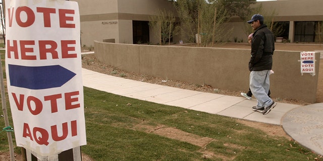 Lupe Montoya (wearing cap) and his neighbor Juana Nicholas, of El Mirage, Arizona walk to the El Mirage Youth Center, February 3, 2004 where they will vote in the state's democratic presidential primary election. (Photo by Jeff Topping/Getty Images)