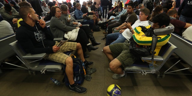 Passengers wait after flights were delayed due to heavy fog, in World Cup host city Curitiba, Brazil, June 17, 2014.
