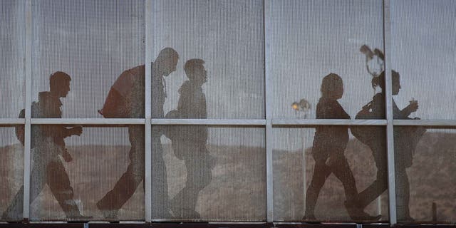 TIJUANA, MEXICO - OCTOBER 02: A group of immigrants walks into Mexico after being deported by U.S. immigration authorities on October 2, 2013 to Tijuana, Mexico. Despite the U.S. federal shutdown, most border agents have been categorized as essential personnel and continue working. (Photo by John Moore/Getty Images)