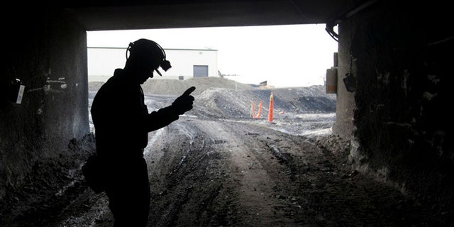 In this November 9, 2010 file photo, a mine employee stands at the entrance to Signal Peak Energy's Bull Mountain mine in Roundup, Montana.