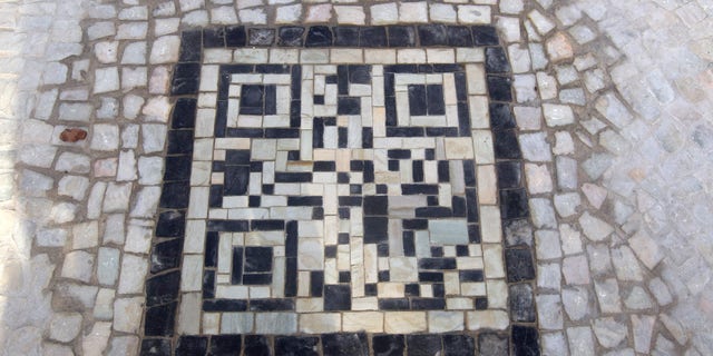 A two-dimensional bar code, or QR code, as they're known, made from black and white stones covers a sidewalk near the beach in Rio de Janeiro, Brazil, Friday, Jan. 25, 2013. The QR codes are being placed at tourist spots which can be scanned with a mobile device for information about the site. (AP Photo/Silvia Izquierdo)