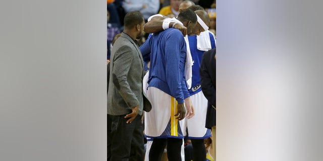 Golden State Warriors center Jermaine O'Neal, right, is helped off the floor after being injured during the fourth quarter of an NBA basketball game against the Utah Jazz in Oakland, Calif., Saturday, Nov. 16, 2013. The Warriors won 102-88. (AP Photo/Jeff Chiu)