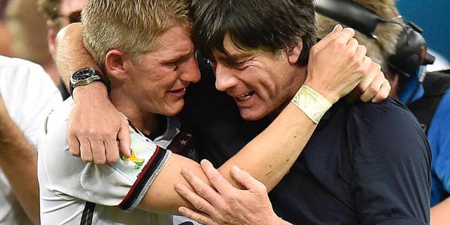 Germany's Bastian Schweinsteiger and Germany's head coach Joachim Loew embrace after the World Cup final soccer match between Germany and Argentina at the Maracana Stadium in Rio de Janeiro, Brazil, Sunday, July 13, 2014. Germany won the match 1-0 (AP Photo/Martin Meissner)