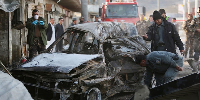 April 10, 2015: Afghan security personnel gather at the site of a suicide attack in Kabul, Afghanistan.
