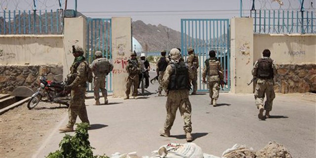 U.S. soldiers, left, and Afghan Police Commando forces, right, are seen at a university after a bomb blast in Kandahar, Afghanistan, on June 4.