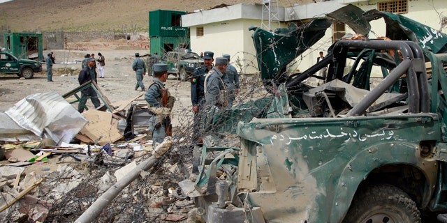 April 14: Afghan police men and officials stand close to a damaged police vehicle at the scene of a suicide car bomb explosion on the out skirts of Kabul, Afghanistan. A suicide car bomber detonated a truck of explosives covered in wood at a government compound in Musayi district, about 40 miles south of the Afghan capital, according Daud Amin, deputy police chief in Kabul. Six members of the Afghan national security forces were injured, he said. (AP)